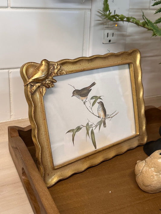 Decorative gold frame with a print of birds on a branch